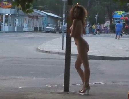 Городская нудистка без одежды гуляет по улице и позирует голой Городская нудистка без одежды гуляет по улице и позирует голой